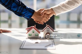Real estate agents shake hands after the signing of the contract agreement is complete.