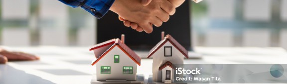 Real estate agents shake hands after the signing of the contract agreement is complete.